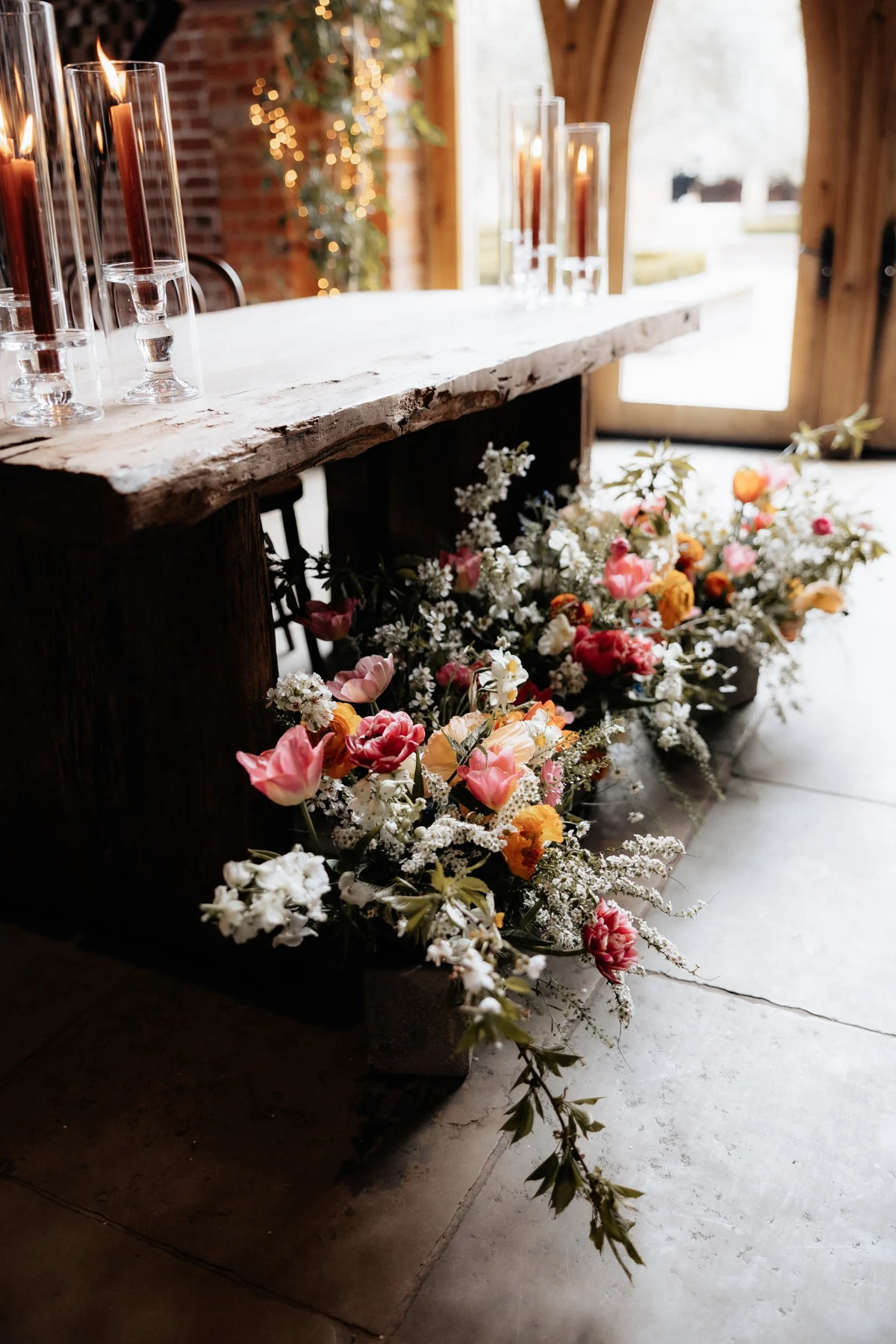 Wedding flowers arranged beside a fireplace